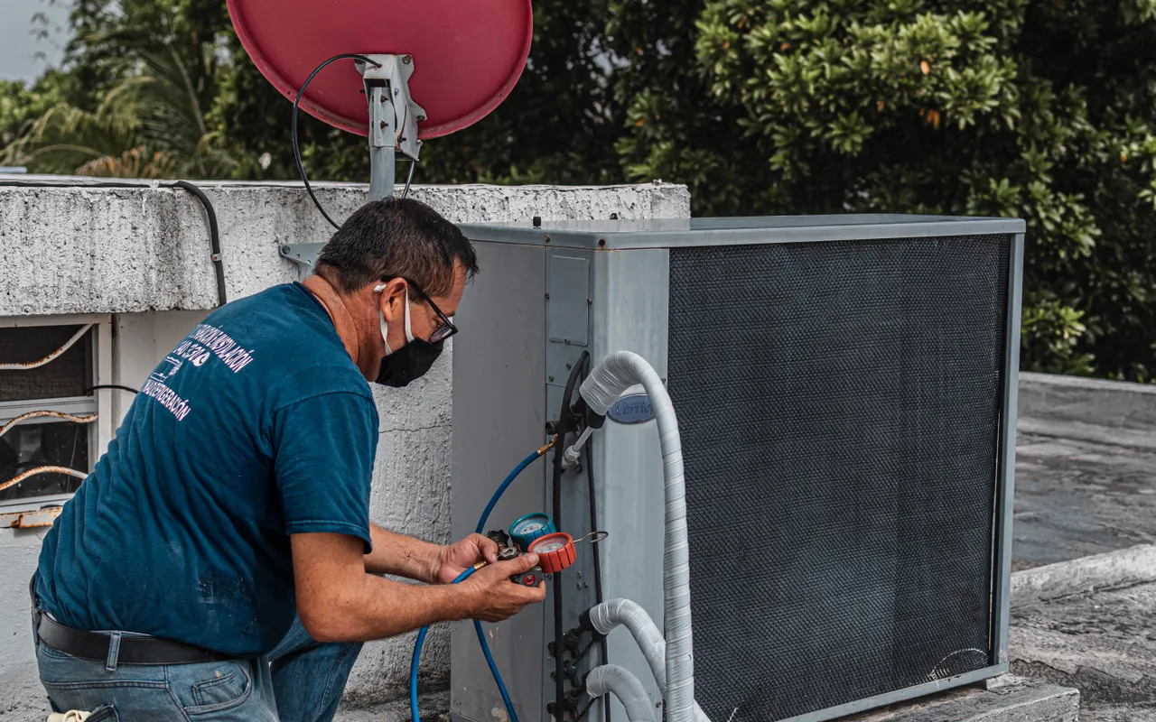 Monteur onderhoudt een airconditioninginstallatie